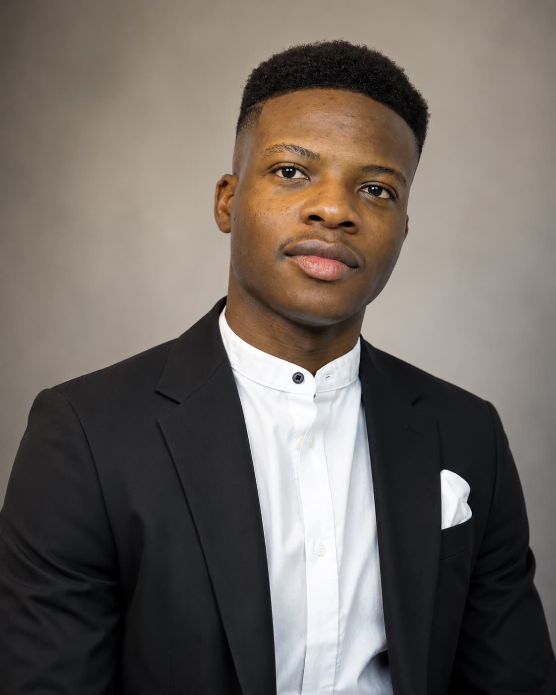 Ayomide Oribamise wearing a black suit and white shirt